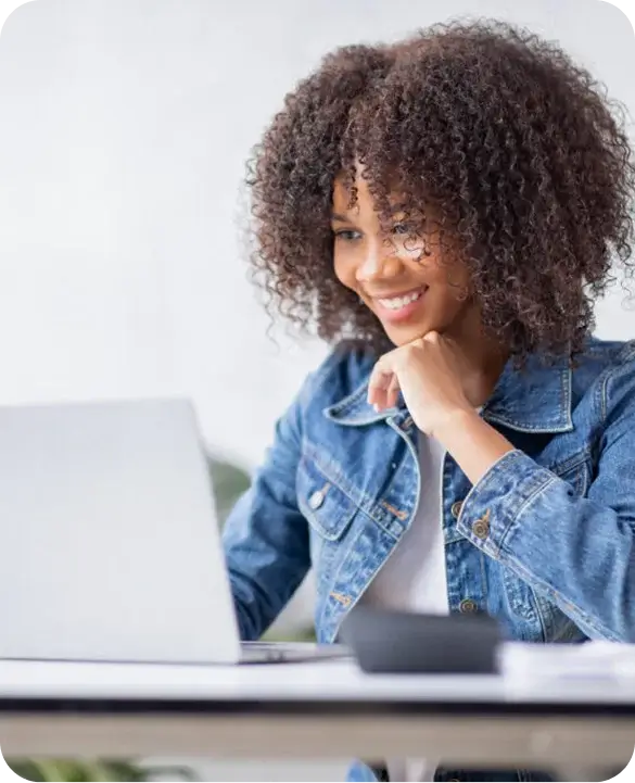 Woman Smiling at Laptop Applying for HVAC Financing with GoodLeap