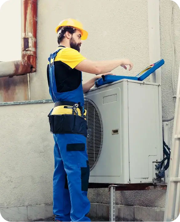 HVAC Technician in Hard Hat Servicing Outdoor AC Unit