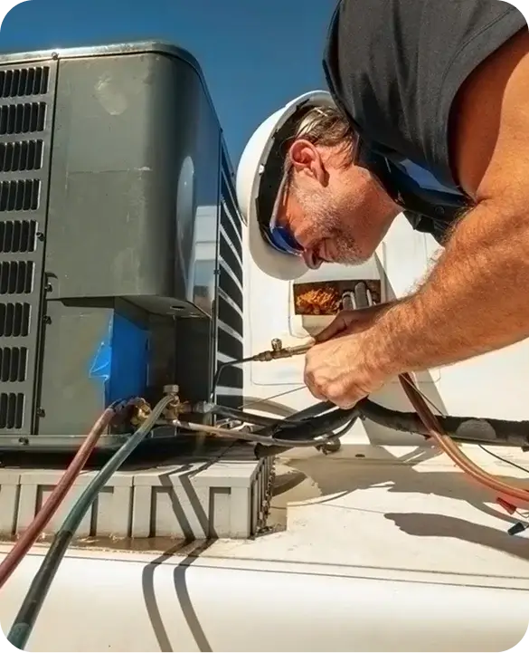 HVAC technician repairing outdoor AC condenser unit