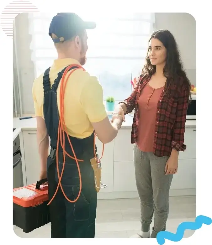 HVAC technician shaking hands with homeowner in kitchen