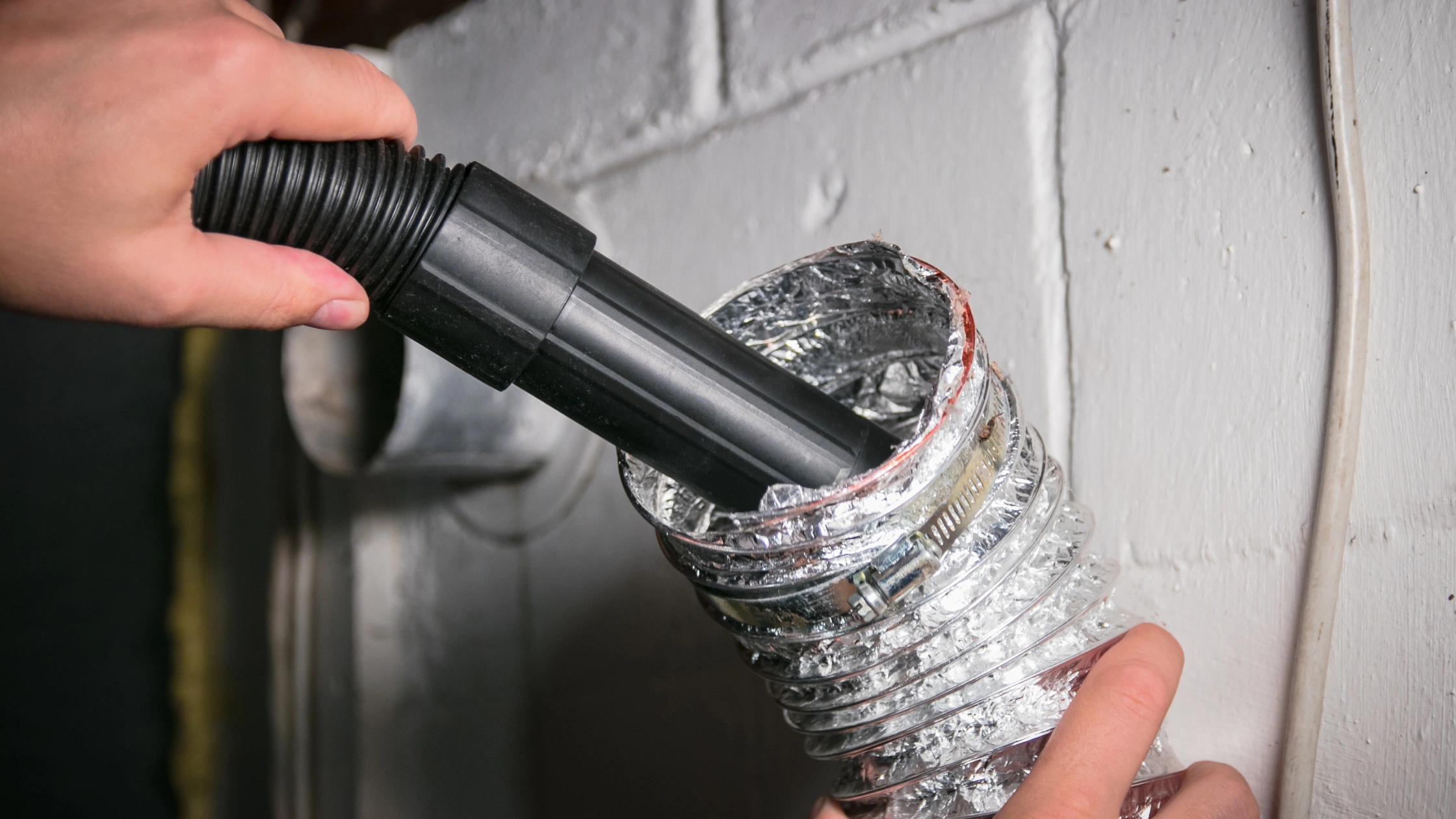 Technician Vacuuming Flexible HVAC Ductwork During Duct Repair St Petersburg FL