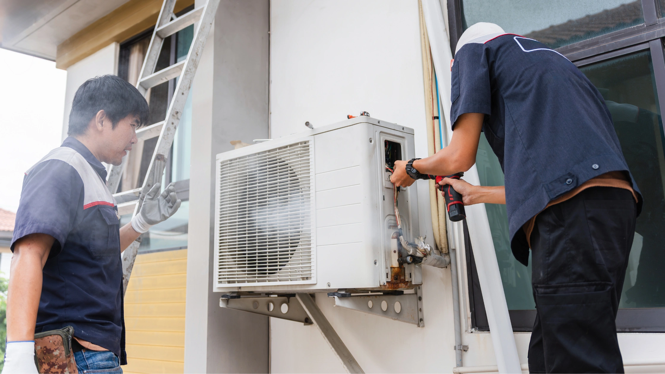 Two HVAC Technicians Installing Mini Split AC Unit on Home Exterior Gulf Coast